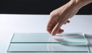 a hand tapping on a clear acrylic sheet-3