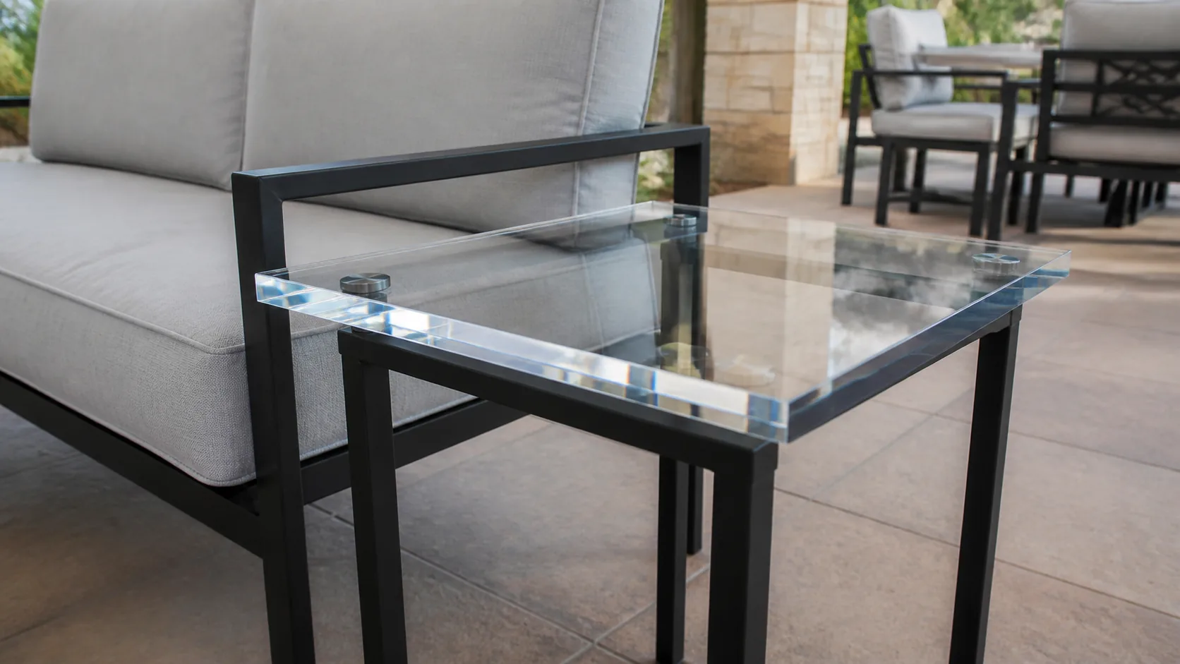Polished acrylic outdoor side table on a metal frame